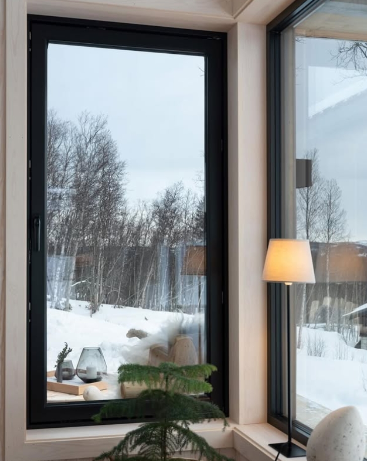 H&oslash;yt, innadsl&aring;ende vindu med sort karm og utsikt mot sn&oslash;landskap.
